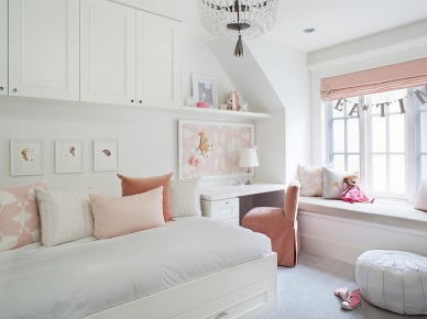 Białe łóżko z szafkami na ścianie,małe biurko i zabudowa z siedziskami przy oknie z różową roletą i poduszkami dekoracyjnymi (26765)
